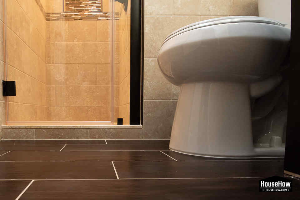 We always install the toilet on the ceramic tiles, never make tiles around it